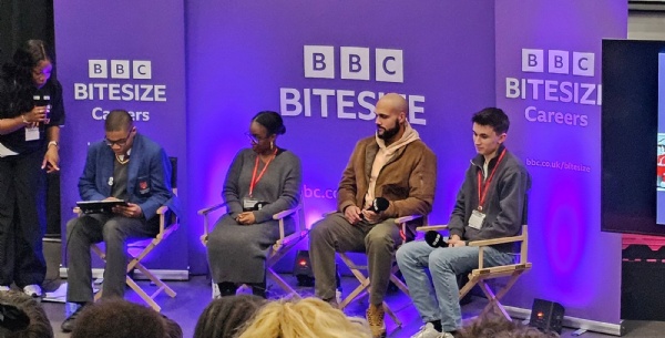 Students sitting with presenters in front of a BBC Bitesize big screen.